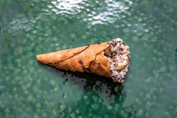 Hazelnut chocolate in a crunchy cone. Served on a textured green plate. Gourmet delicacies and...