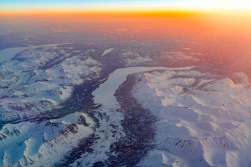 Aerial view of snow mountain and frozen river in colorful morning sunlight in Alaska