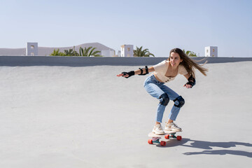 Young Woman Surfing Down Ramp on Skateboard