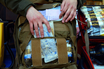 Backpack with soldier s first aid kit: bandages, wound-healing drugs, balloon with burn-treating...