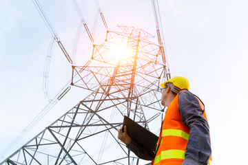 An electrician is checking the electrical transmission at a high-voltage pole.