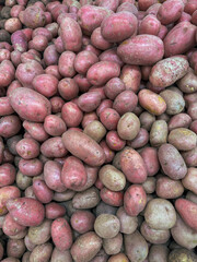Pink potatoes on a market counter as a background. Texture