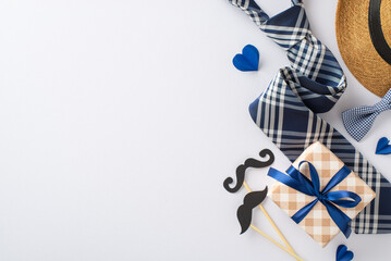 Cherished Dad: Top view photo featuring a straw hat, stylish necktie, bow tie, gift box, glasses, mustache props, and paper hearts on white. An ideal setup for Father's Day messages or advertisements
