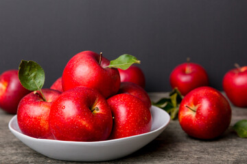juicy red apples in a bowl or plate on the table top view. Copy space