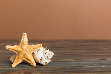 Summer time concept with sea shells or starfish on a table background with copy space for text
