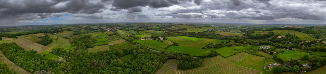 Fototapeta na wymiar Aerial view of Bordeaux vineyard at spring under cloudy sky, Rions, Gironde, France. High quality photo