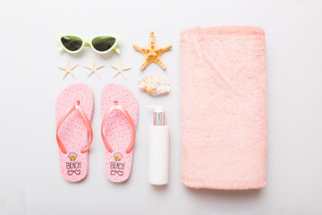 Summer holiday concept. Top view of beach towel, flip flop and sunscreen cream on table Top view with copy space for text - obrazy, fototapety, plakaty