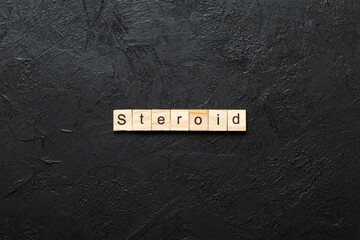 steroid word written on wood block. steroid text on table, concept