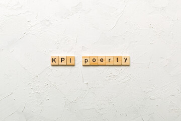 kpi word written on wood block. key performance indicators text on table, concept