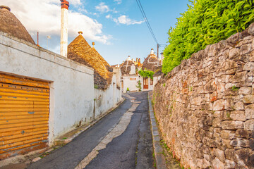 Trulli of Alberobello, Puglia, Italy. town of Alberobello with trulli houses among green plants and...