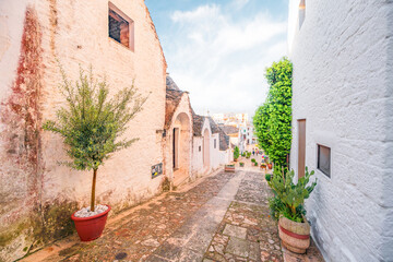 Trulli of Alberobello, Puglia, Italy. town of Alberobello with trulli houses among green plants and...