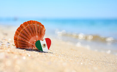Sandy beach in Mexico. Mexico flag in the shape of a heart and a large shell. A wonderful seaside...