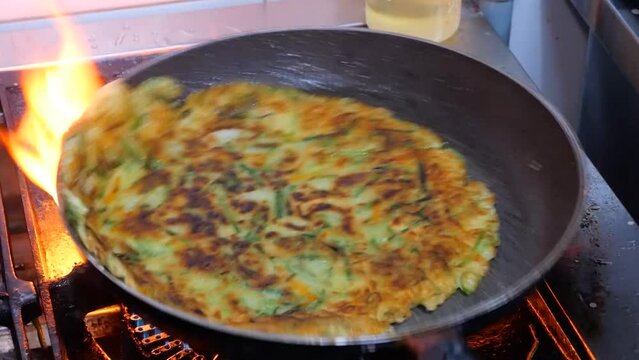 달궈진 후라이팬에서 먹음직스럽게 조리되는 부침개