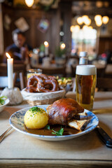 Traditionelle Schweinshaxe mit Knödel und Bier im gemütlichen Wirtshaus