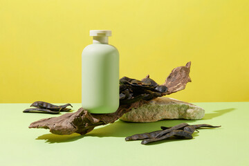 A pile of black locust fruits and an empty label bottle displayed on a tree branch. Green surface. Washing your hair with Black Locust regularly reduces the amount of dandruff