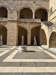 Old Greek marble statues and fountain in the courtyard of the palace of the grand master of the knights of Rhodes in medieval city of Rhodes, Greece