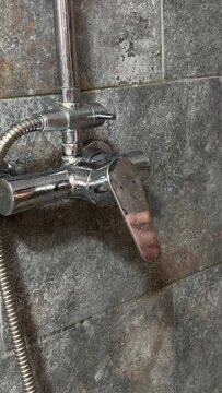 woman's hand opens the hot and cold water tap to water for bathing. Close-up of a beautiful faucet