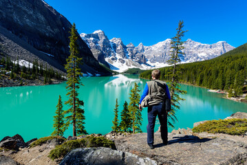 A tourist man enjoys the view of Moraine Lake in summer, Banff National Park