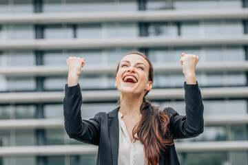 portrait of excited outdoor business woman celebrating success