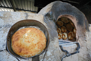 Baking hot flatbreads in traditional central asian tandoor
