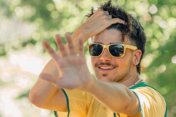 portrait of smiling young man in sunglasses and yellow t-shirt in summer