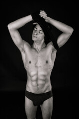 Naklejka premium A young attractive man with a beautiful body posing in the studio.