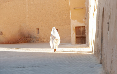 A woman wears the traditional white haik ,is worn by most women, Ghardaia, Algeria