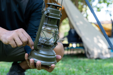 A camper is hanging a lantern while camping