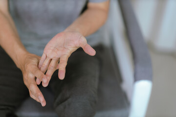 Senior man with arthritis rubbing hands