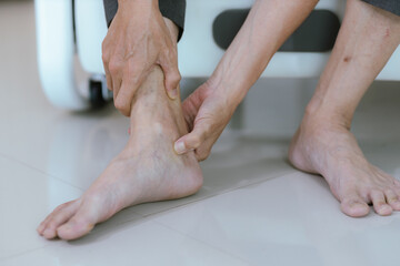 Close-up of an elderly man whose ankle hurts from walking too much. Massage painful feet and knees...