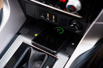 Wireless mobile charger in the modern car. Portable wireless car charger for smartphone.	