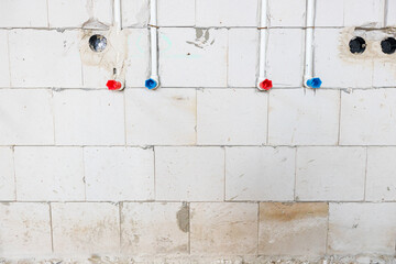 System of white plastic pipes installed in the wall for water supply