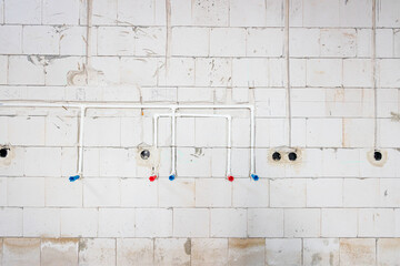 System of white plastic pipes installed in the wall for water supply