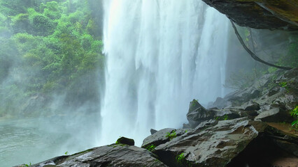 Inside a lush cave, a mesmerizing tropical waterfall cascades into a crystal-clear pool, a hidden...