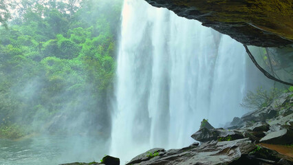 Inside a tropical cave, mesmerizing waterfall cascades into emerald pool, nature's hidden treasure. Huai Luang Waterfall, Phu Chong Na Yoi national park, Ubon Ratchathani Province, Thailand.   © Punyawee