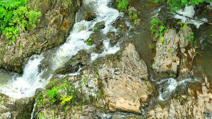 Serene waterfall, enveloped by lush, tranquil rainforest, offering a serene escape from the...