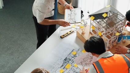 Top view of professional architect engineer team inspect house model while manager holding...