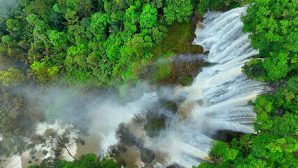 Nature's grandeur on display: a colossal waterfall concealed in the heart of a tropical rainforest....