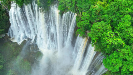 Unveiling the secret beauty of an exotic jungle oasis, a majestic waterfall hidden amidst a dense...
