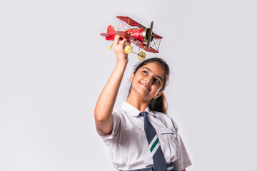 Indian asian cute little school kid studying aeroplane with a model plane