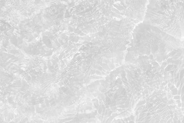 White water with ripples on the surface. Defocus blurred transparent white colored clear calm water surface texture with splashes and bubbles. Water waves with shining pattern texture background.
