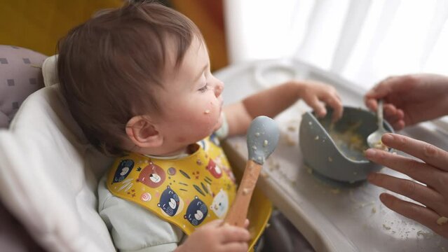 baby dirty eats. happy family toddler concept. baby girl learns to eat with her hands dirty her face dirty funny video. dirty baby on the table for feeding dream eats with her hands from a cup