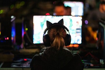 Teenager girl gamer play video game on PC computer