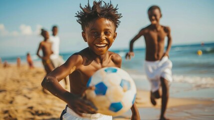 A young boy is holding a soccer ball on a beach - Powered by Adobe