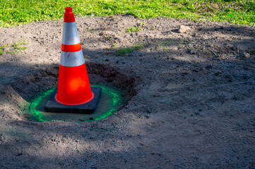 Orange traffic cone marks dangerous sunken manhole cover public park danger safety cone