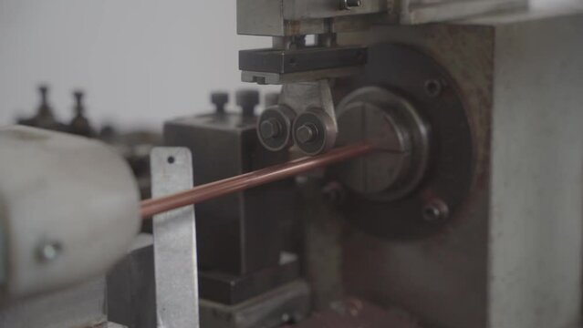 Factory production of heat exchanger. Heavy machinery cutting copper tubes in workshop. Lots of pipes to produce. Heating element. Close up.