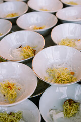 Multiple bowls of noodle soup fully prepared with noodles and seasonings, ready to be served and enjoyed