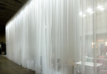 Large white tulle curtains divide the space into two parts.