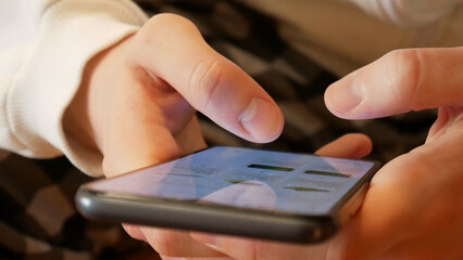 Close-up of two male hands holding a smartphone and browsing a web store