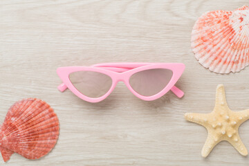 Stylish yellow sunglasses on wooden background, top view. Summer concept
